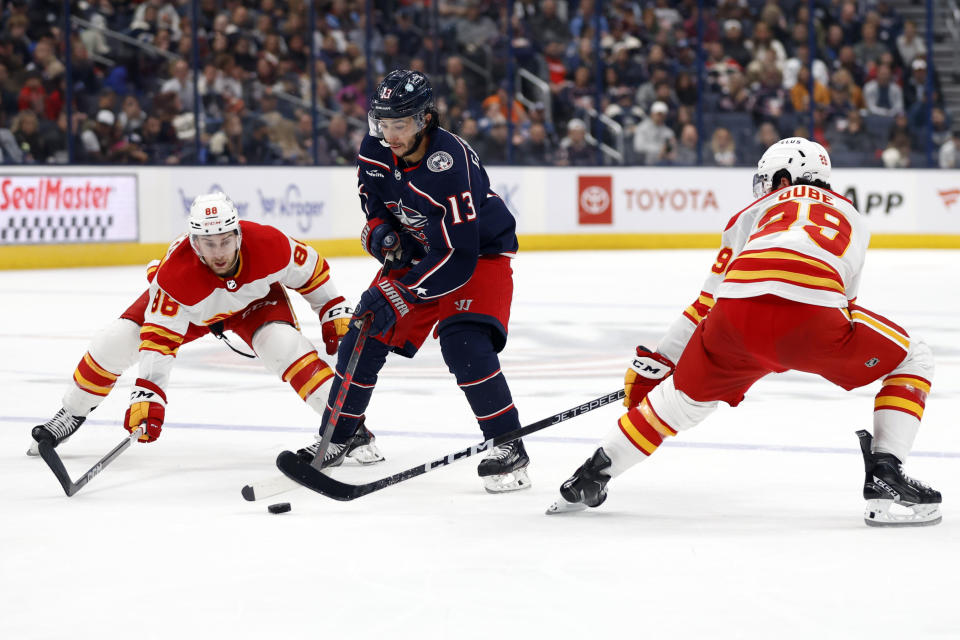Columbus Blue Jackets forward Johnny Gaudreau, center, skates between Calgary Flames forwards Andrew Mangiapane, left, and Dillon Dube during the second period of an NHL hockey game in Columbus, Ohio, Friday, Oct. 20, 2023. (AP Photo/Paul Vernon)
