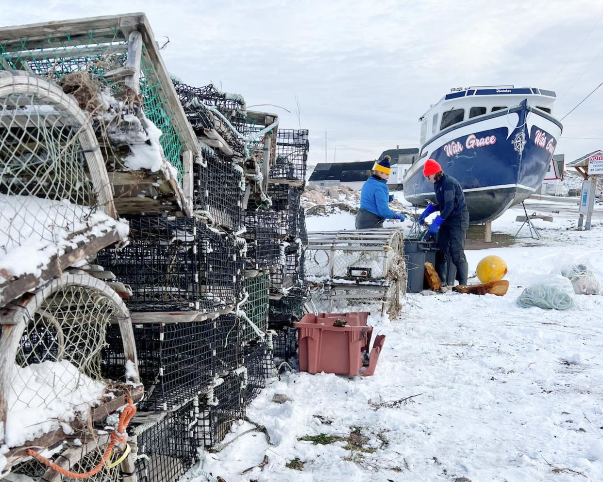 Workers with Coastal Action gather lobster traps and rope during a ghost gear cleanup on shore in Neils Harbour, N.S., in early December. (Matthew Molyneux/Coastal Action - image credit)