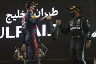 Mercedes driver Lewis Hamilton of Britain, winner, right, celebrates with Red Bull driver Max Verstappen of the Netherlands on the podium after the Bahrain Formula One Grand Prix at the Bahrain International Circuit in Sakhir, Bahrain, Sunday, March 28, 2021. (Lars Baron, Pool via AP)
