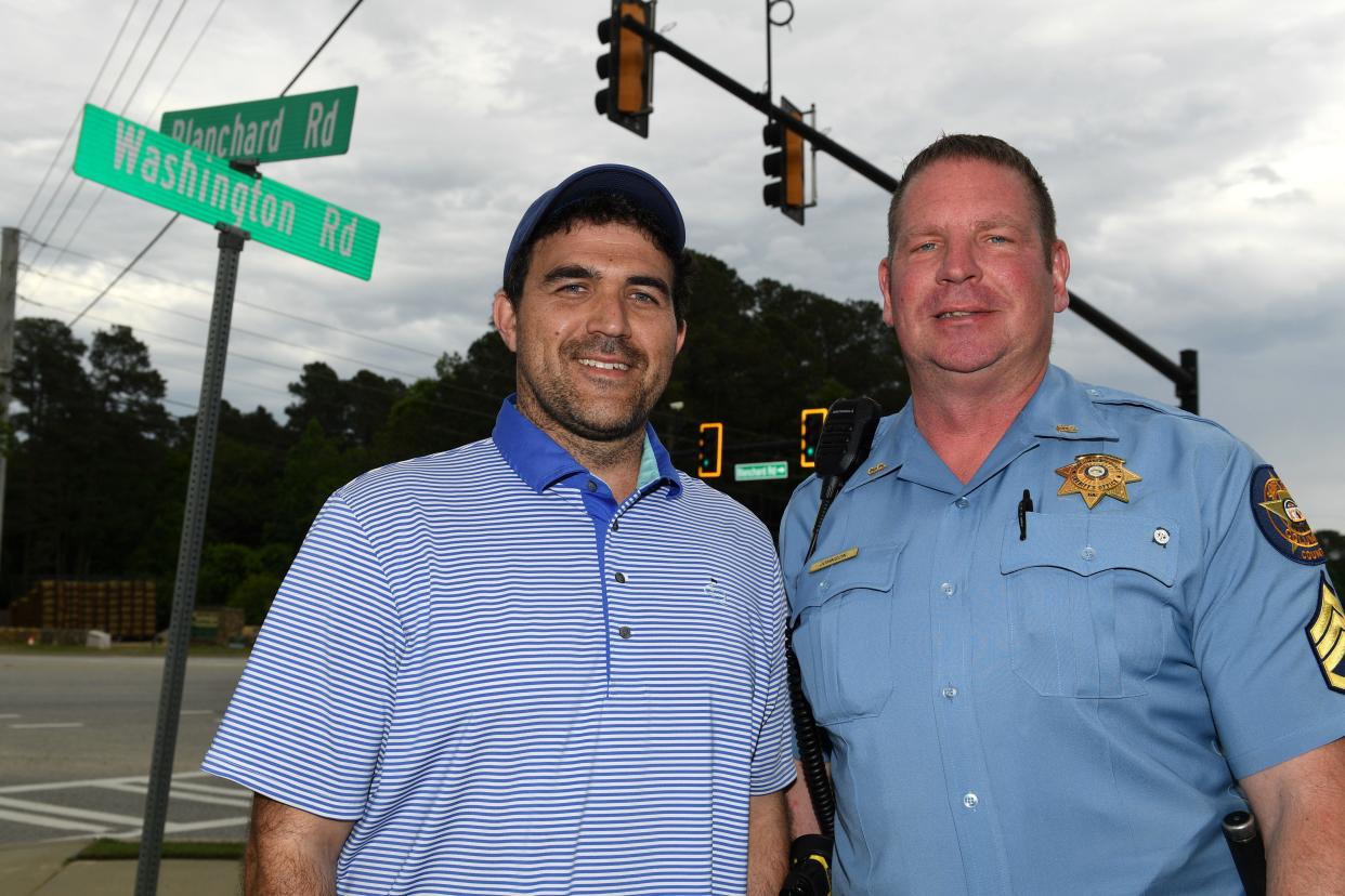 Will Johnson and Deputy Tim Johnson pose for portrait at the intersection of Washington Road and Blanchard Road on Tuesday, April 30, 2024.