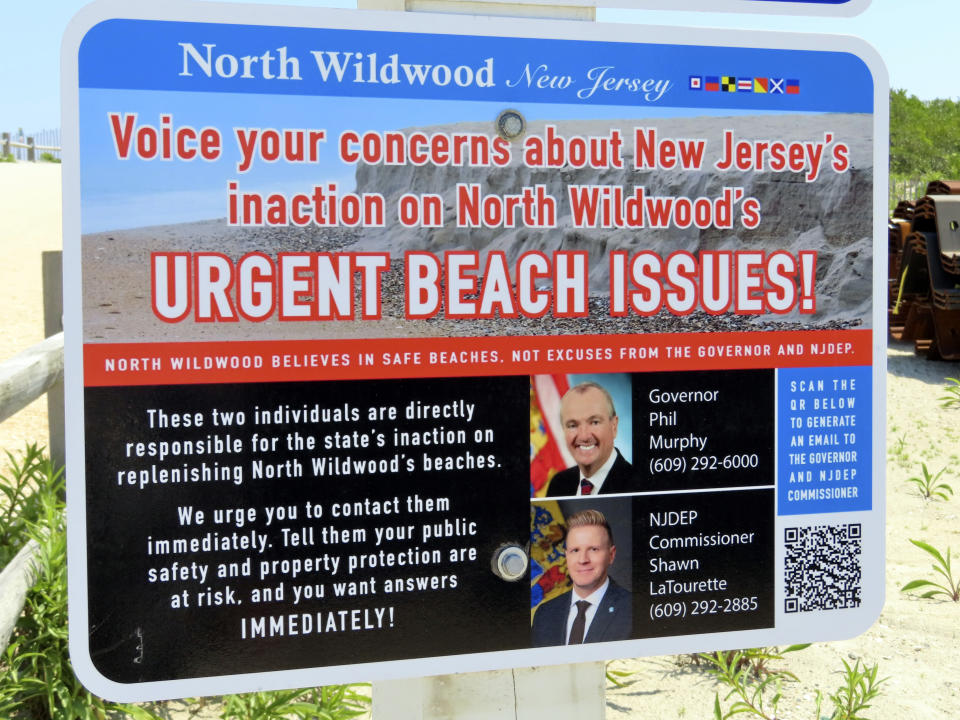 A sign posted the entrance to a beach in North Wildwood, N.J., is shown on Friday, July 7, 2023, blaming New Jersey's governor and its environmental protection commissioner for the lack of progress on widening the city's beaches. (AP Photo/Wayne Parry)