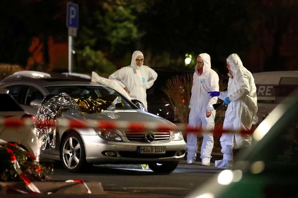 Forensic experts work around a damaged car after a shooting in Hanau: REUTERS