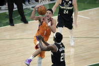 Phoenix Suns guard Devin Booker (1) drives to the basket against Milwaukee Bucks guard Jrue Holiday (21) during the first half of Game 6 of basketball's NBA Finals Tuesday, July 20, 2021, in Milwaukee. (AP Photo/Aaron Gash)