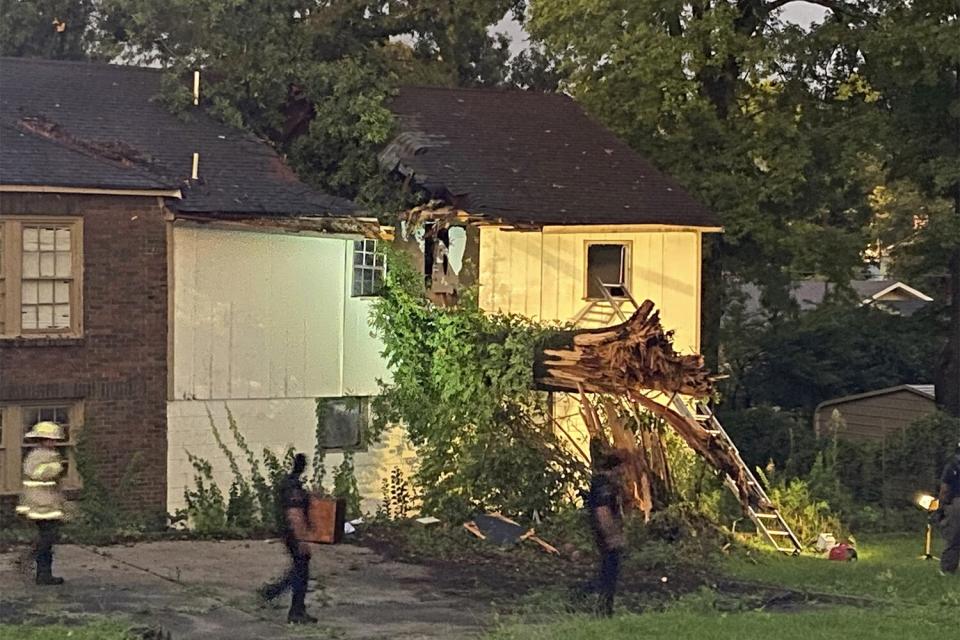 Birmingham Fire and Rescue Service respond to a home after a tree fell after a storm on Thursday, July 21, 2022 in Birmingham, Ala. Battalion Chief Sebastian Carrillo said they arrived to find the massive tree had smashed into the brick home. (Carol Robinson/AL.com via AP)