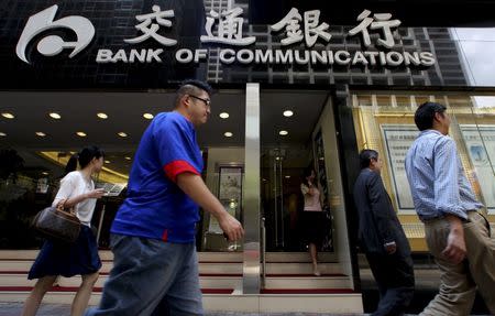 People walk past the Bank of Communications at its central branch in the financial district of Hong Kong August 19, 2009. REUTERS/Aaron Tam/File Photo