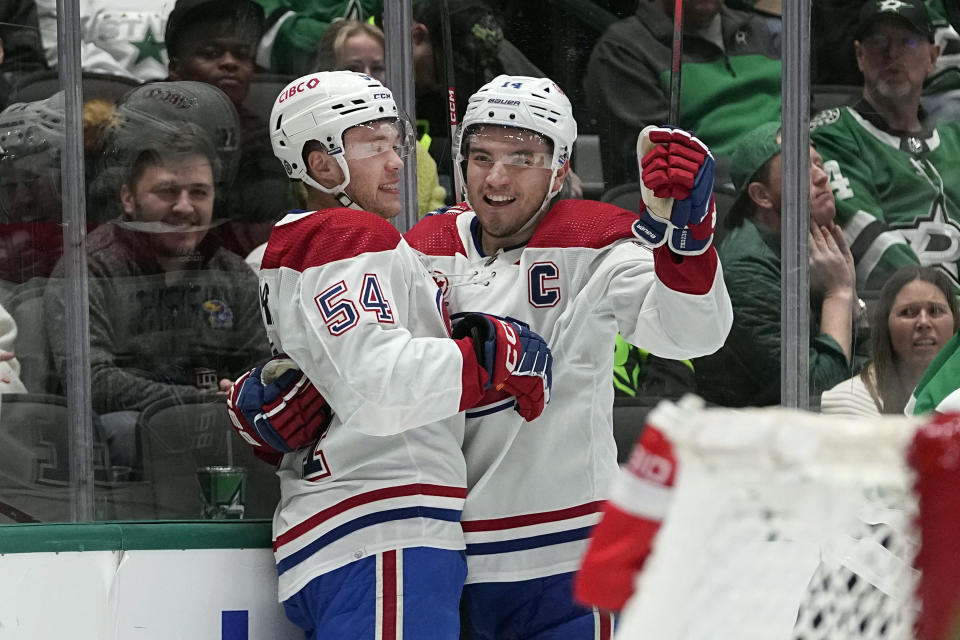 Montreal Canadiens defenseman Jordan Harris (54) celebrates a goal with teammate center Nick Suzuki (14) during the second period an NHL hockey game against the Dallas Stars in Dallas, Tuesday, Jan. 2, 2024. (AP Photo/LM Otero)