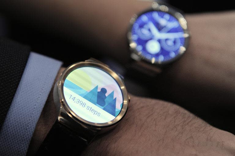 Two models show the new Huawei's device "Huawei Watch" during a press conference in Barcelona, Spain, on March 1, 2015