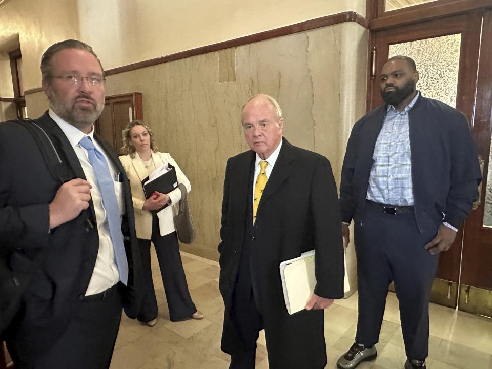 Former NFL football player Michael Oher, right, stands with his lawyers outside a courtroom, Wednesday, Nov. 29, 2023, in Memphis, Tenn. A lawyer for the Memphis couple who took in former NFL player Michael Oher when he was in high school said Wednesday, Nov. 29, 2023, that references to Oher being their adopted son will be removed from the couple’s websites and public speaking materials as part of their legal battle over Oher’s finances. (AP Photo/Adrian Sainz)