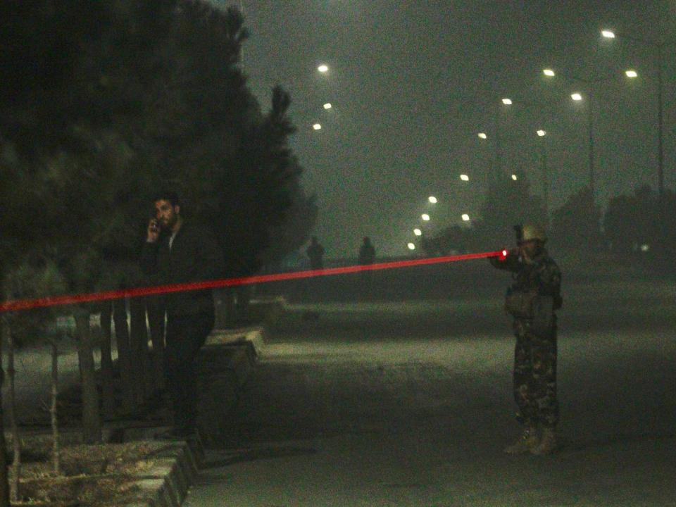 Afghan security officials take up positions near the scene of attack by armed men at a hotel in Kabul (EPA)