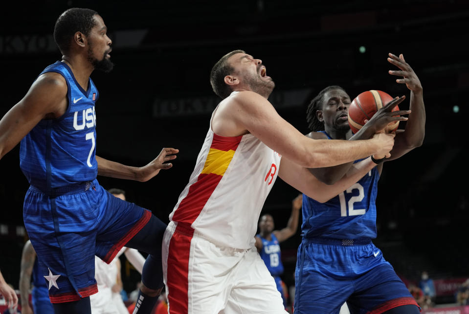 Spain's Marc Gasol (13), center, fights for a rebound with United States' Jrue Holiday (12), right, and Kevin Durant (7), left, during men's basketball quarterfinal game at the 2020 Summer Olympics, Tuesday, Aug. 3, 2021, in Saitama, Japan. (AP Photo/Eric Gay)