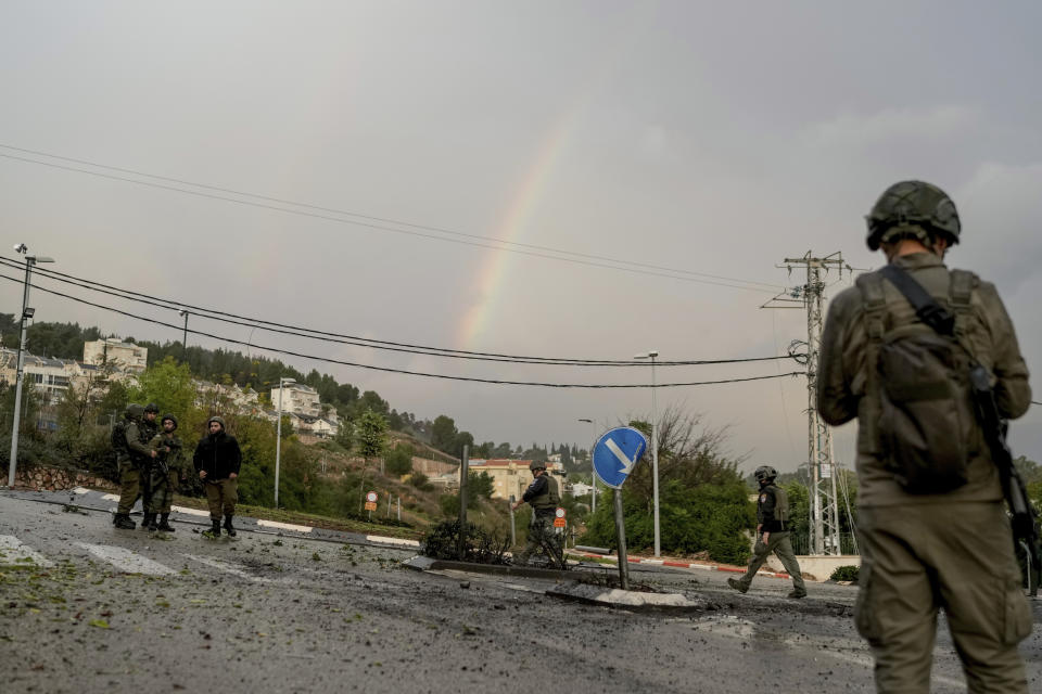 Israeli security forces examine a road hit by a rocket fired from Lebanon, in Kiryat Shmona, northern Israel, Thursday, Jan. 11, 2024. (AP Photo/Leo Correa)