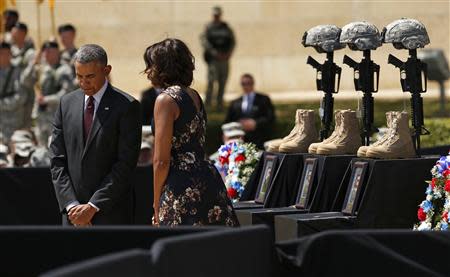 U.S. President Barack Obama and first lady Michelle Obama pay their respects for the dead soldiers at the conclusion of a memorial service in Fort Hood, Texas April 9, 2014. REUTERS/Kevin Lamarque