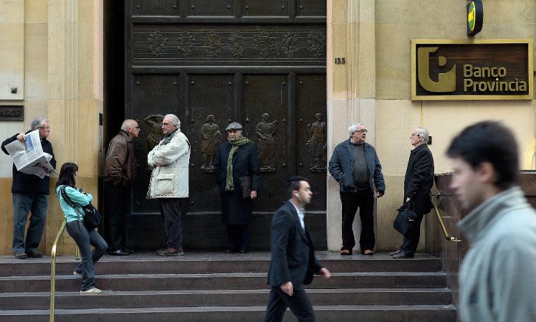 Retired citizens await the opening of the Banco Provincia bank headquarters in the financial district near Plaza de Mayo square to collect their pensions, in Buenos Aires on July 30, 2014