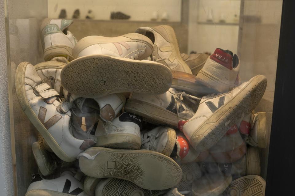 Veja shoes pile up in a store in Paris, Monday, Jan. 9, 2023. Veja, an expensive global sneaker brand, is producing sneaker soles made of native Brazilian Amazon rubber in collaboration with local rubber-tapping cooperatives. Over the last 20 years, Veja has sold more than 8 million pairs in several countries and maintains stores in Paris, New York and Berlin. (AP Photo/Thibault Camus)