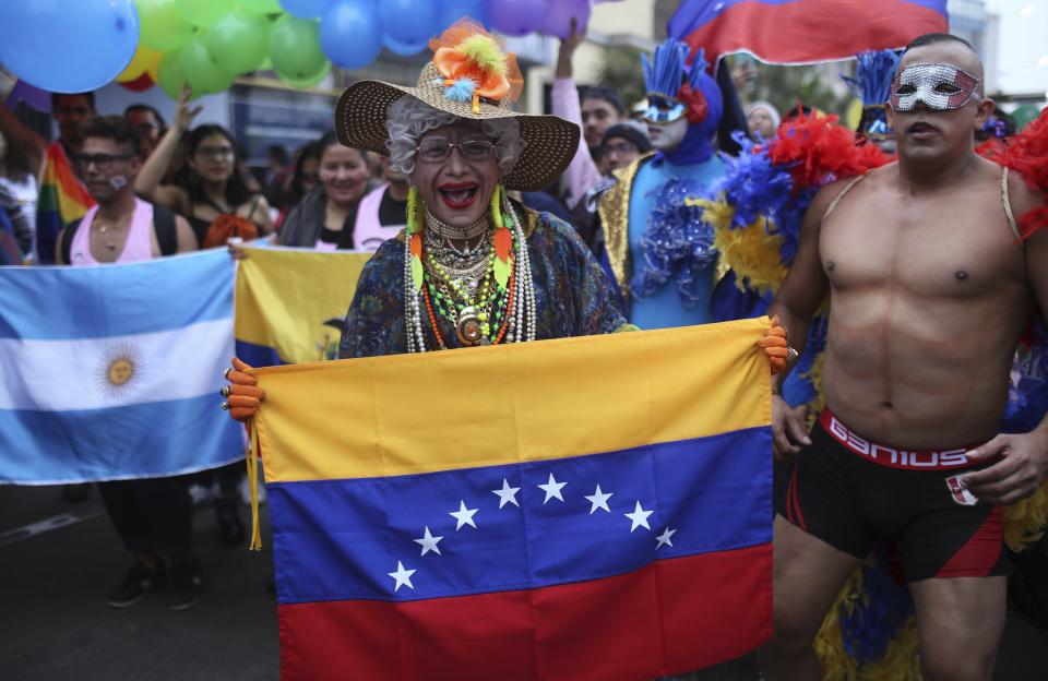 Revelers gather with a Venezuelan flag for the annual gay pride parade in Lima, Peru, Saturday, June 29, 2019. (AP Photo/Martin Mejia)