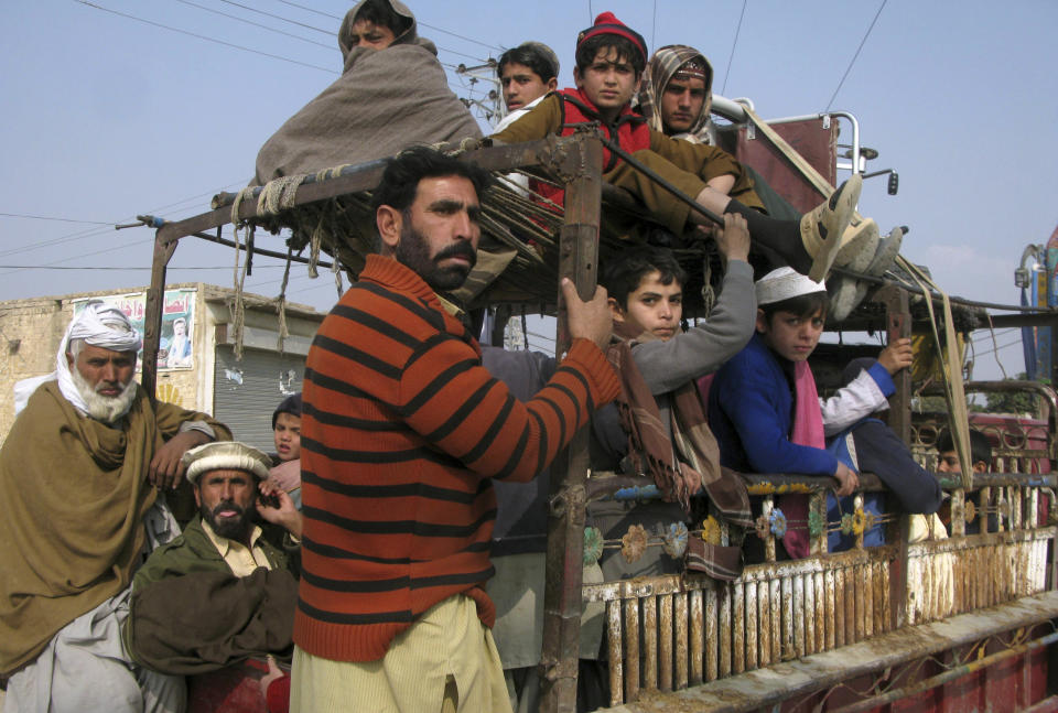 Pakistani tribal villagers sit on the back of a vehicle as they pass through Bannu, Pakistan, after fleeing there homes due to a crackdown operation by the army against militants, Tuesday Jan. 21, 2014. Pakistani fighter jets pounded militant positions overnight in the country’s northwest following a Taliban bombing campaign against security forces, military officials and residents said Tuesday. The strikes are likely to hamper the government’s efforts to hold peace talks with the Pakistani Taliban. (AP Photo/Ijaz Muhammad)