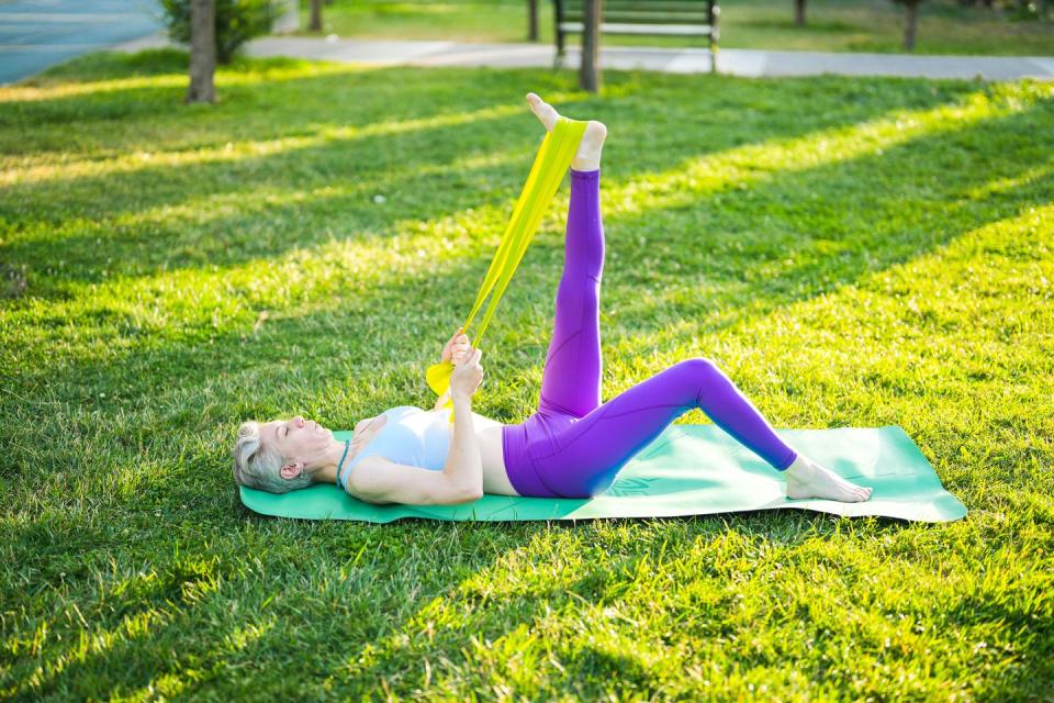 fit athletic short hair woman stretching on mat in park