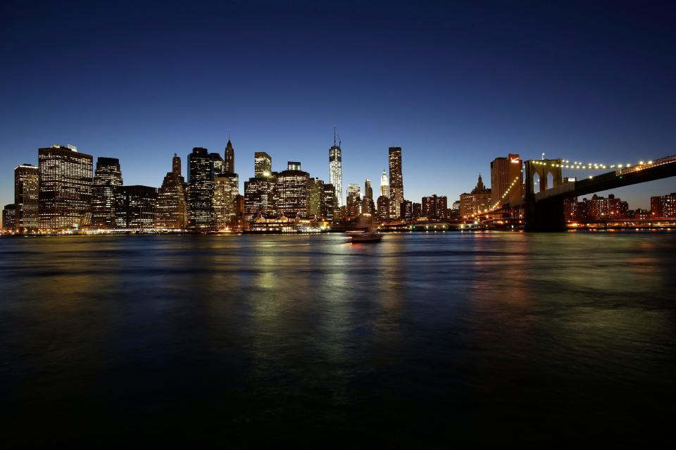 One World Trade Center, center, towers above the lower Manhattan skyline, the East River, and the Brooklyn Bridge, right, Aug. 14, 2013, in New York.