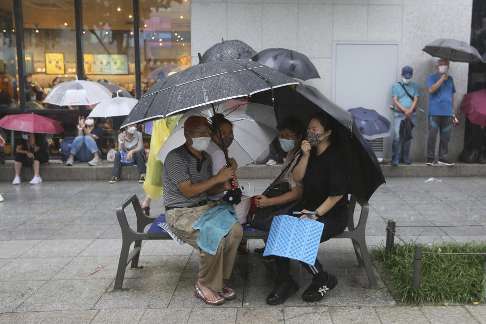 Protesters wearing face masks hold umbrellas in the rain during a rally against the government in Seoul, South Korea, Saturday, Aug. 15, 2020. Thousands of anti-government protesters, armed with umbrellas and raincoats, marched through the soggy streets of South Korea's capital Saturday, ignoring official pleas to stay home amid a surge in coronavirus infections. (AP Photo/Ahn Young-joon)