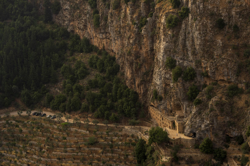 Tourists visit the Saint Elisha monastery inside the Kadisha Valley, a holy site by Lebanon's Christians, in the northeast mountain town of Bcharre, Lebanon, Friday, July 21, 2023. For Lebanon's Christians, the cedars are sacred, these tough evergreen trees that survive the mountain's harsh snowy winters. They point out with pride that Lebanon's cedars are mentioned 103 times in the Bible. (AP Photo/Hassan Ammar)