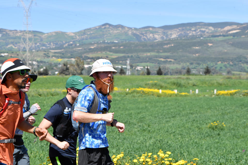 Britain's Russ Cook (R) runs, with supporters who joined him for the final leg of the 16,000km challenge to run the length of Africa from South Africa's Cape Agulhas to Tunisia's Cape Angela to raise money for charity, in town of Ghazela, north east of Tunis on April 7, 2024. (Photo by FETHI BELAID / AFP) (Photo by FETHI BELAID/AFP via Getty Images)