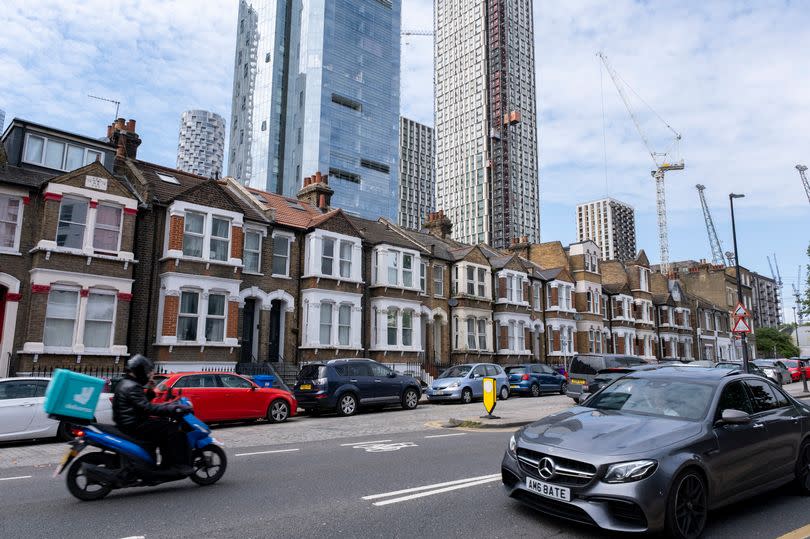 New high rise apartment block towers over an old terrace of low rise homes at the heart of Canary Wharf financial district