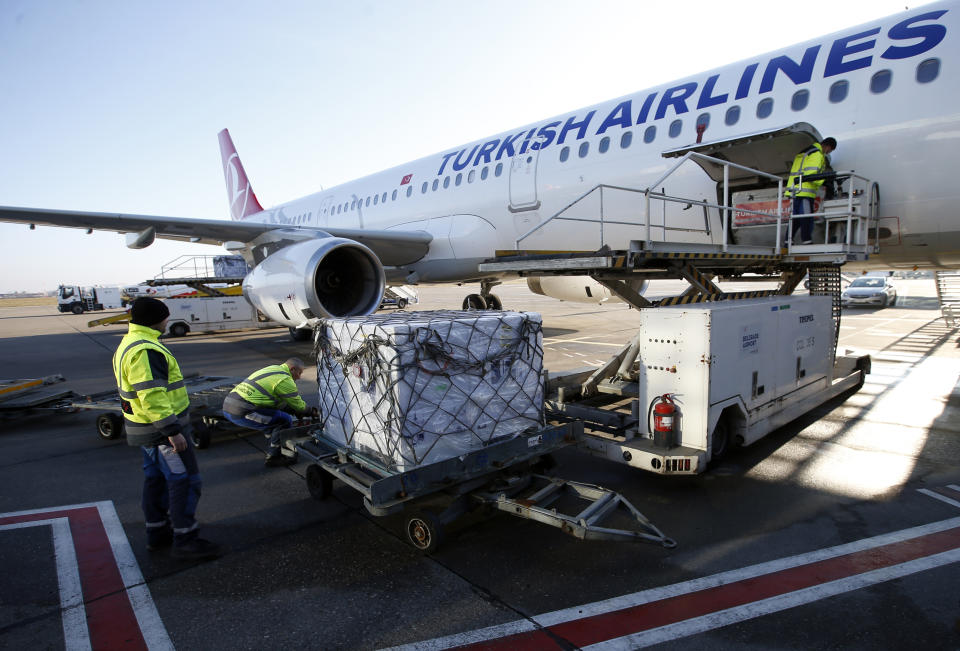 Workers unload boxes of the Astra Zeneca vaccine at the Belgrade Airport, Serbia, Sunday, Feb. 21, 2021. 150,000 doses of Astra Zeneca vaccines were delivered to Serbia. (AP Photo/Darko Vojinovic)