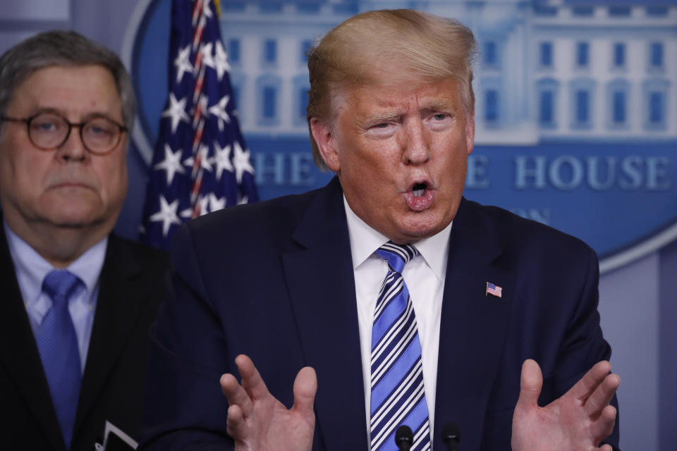 President Donald Trump speaks about the coronavirus in the James Brady Briefing Room, Monday, March 23, 2020, in Washington, as Attorney General William Barr listens. (AP Photo/Alex Brandon)