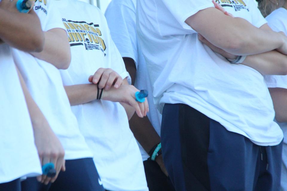 A Hope basketball player stands wearing her Ring Pop stand-in national title ring while the team thanks fans for their support