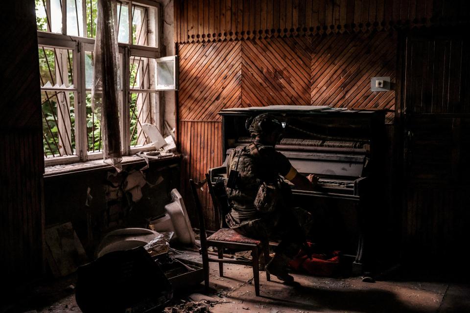 A serviceman of 24th Mechanized brigade named after King Danylo of the Ukrainian Armed Forces plays a piano in a damaged building in the frontline town of Chasiv Yar in Donetsk region (via REUTERS)