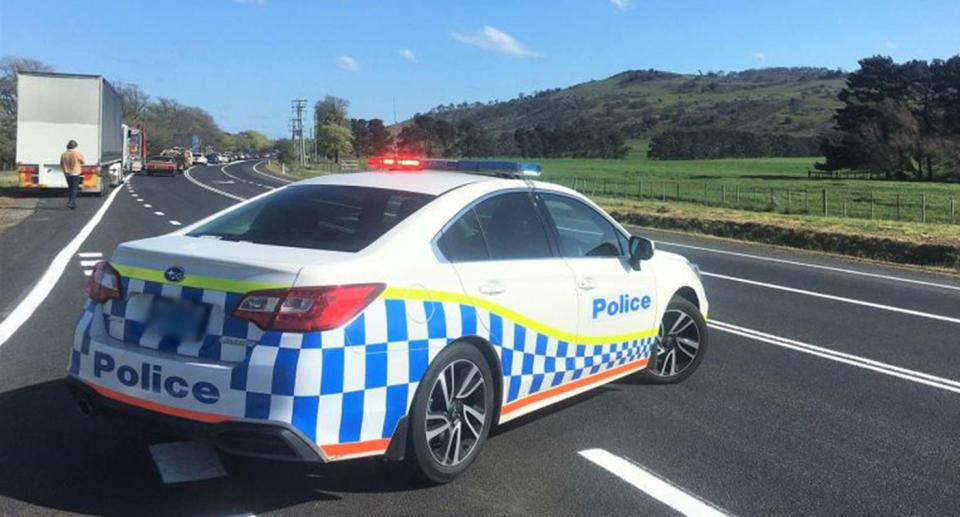 A police car is parked across one of the lanes of the Midland Highway where three people were killed in a horrific car crash.