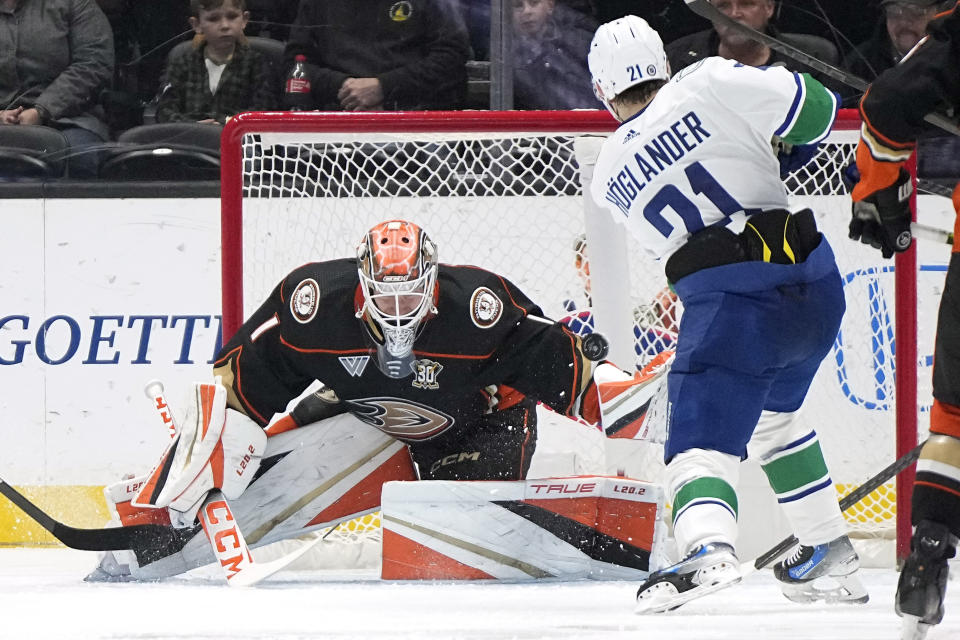 Vancouver Canucks left wing Nils Hoglander, right, shores on Anaheim Ducks goaltender Lukas Dostal during the first period of an NHL hockey game Sunday, March 3, 2024, in Anaheim, Calif. (AP Photo/Mark J. Terrill)