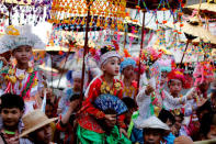 Children are carried on shoulders during an annual Poy Sang Long procession, a traditional rite of passage for boys to be initiated as Buddhist novices, in Mae Hong Son, Thailand, April 3, 2018. REUTERS/Jorge Silva