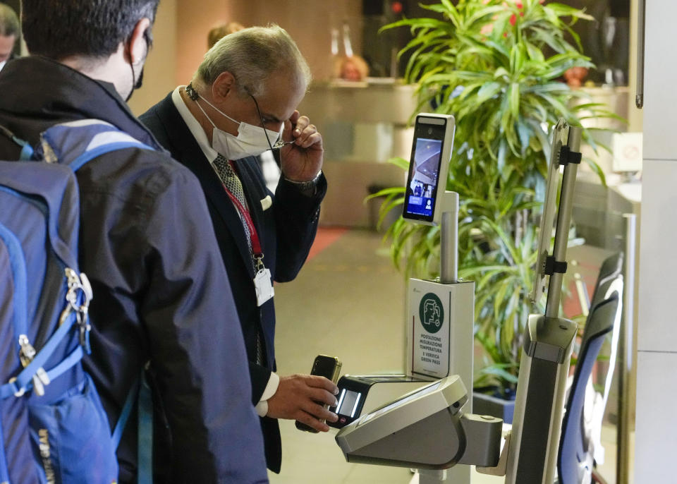 An employee has his certification checked as Italy's new “Green Pass” vaccination requirement for employees to enter their offices became mandatory, at the Trenitalia, Italian train company offices, in Rome, Friday, Oct. 15, 2021. From Friday, certification is required for public and private workplaces. Both employees and employers risk fines if they don’t comply. Public sector workers can be suspended if they show up five times without a Green Pass. The pass is already required in Italy to enter museums, theaters, gyms and indoor restaurants, as well as to take long-distance trains and buses or domestic flights. The passes show that a person has had least one COVID-19 vaccine dose, or recovered from the virus in the last six months, or has tested negative in the last 48 hours. (AP Photo/Andrew Medichini)