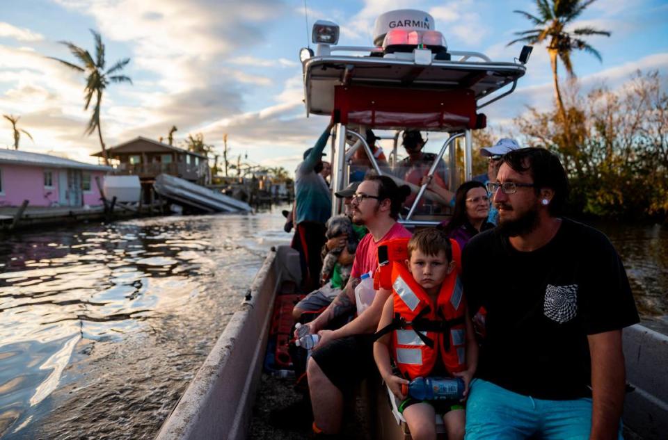 Gotham Tucker, 6, and his dad, Cody Tucker, 31, are ferried to safety by firefighters on Thursday, Sept. 29, 2022, in Matlacha, Fla. Hurricane Ian made landfall on the coast of South West Florida as a category 4 storm Tuesday afternoon leaving areas affected with flooded streets, downed trees and scattered debris.