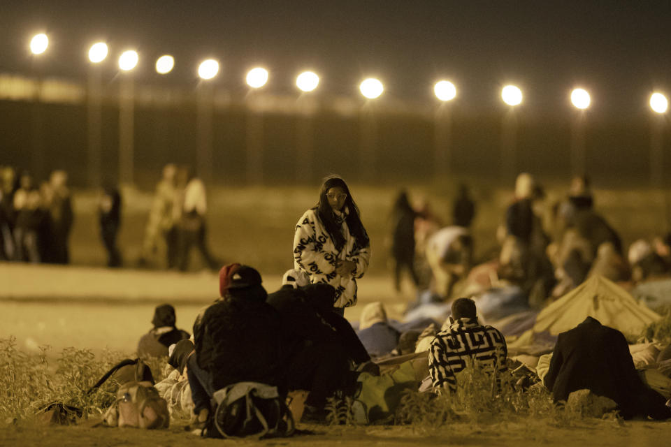 Migrants wait in the cold at a gate in the border fence after crossing from Ciudad Juarez, Mexico into El Paso, Texas, in the early hours of Thursday, May 11, 2023. Migrants rushed across the border hours before pandemic-related asylum restrictions were to expire Thursday, fearing that new policies would make it far more difficult to gain entry into the United States. (AP Photo/Andres Leighton)