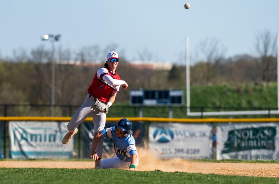 Neshaminy's Danny Nocito (5) throws to first base after forcing out North Penn's Kevin Brace (3) at second base.