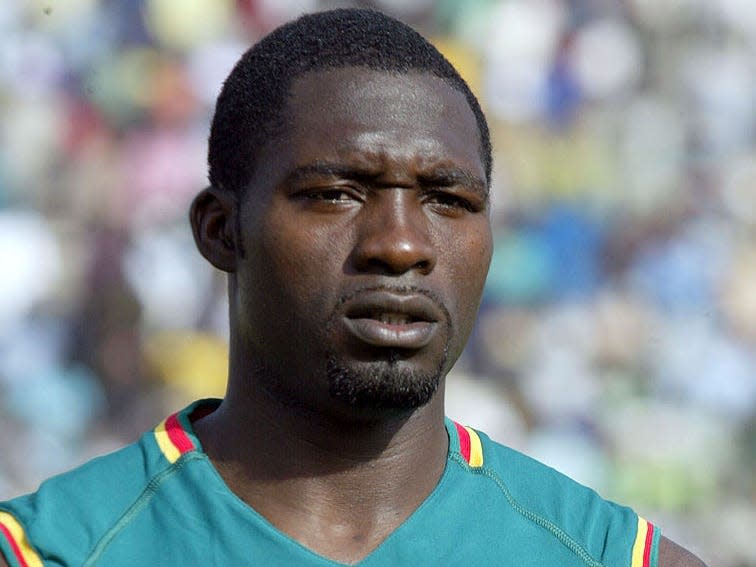 A portrait of Cameroon National soccer team player Marc Vivien Foe in a green jersey.