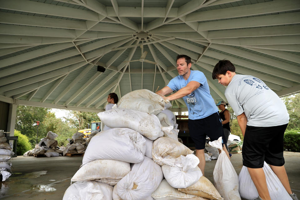 A Boy Scout volunteer and his father help stack sandbags donated by the city of Greenville. (Photo: Chip Somodevilla via Getty Images)