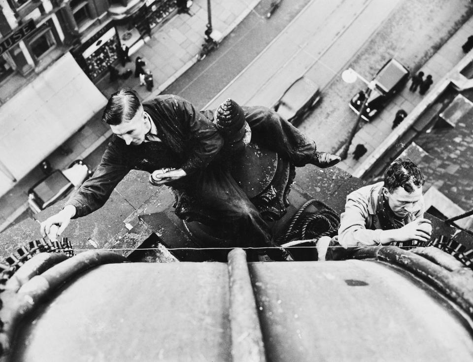 Steeplejacks fix colored map bulbs to the pinnacle of the Town Hall, ahead of the Coronation of George VI and Queen Elizabeth, on April 8, 1937.<span class="copyright">Ward/Fox Photos/Hulton Archive/Getty Images</span>