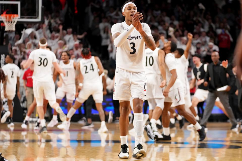 Cincinnati Bearcats guard Mika Adams-Woods (3) celebrates a dunk and timeout along with the team in the first half of a college basketball game between the UCF Knights and the Cincinnati Bearcats, Saturday, Feb. 4, 2023, at Fifth Third Arena in Cincinnati. 