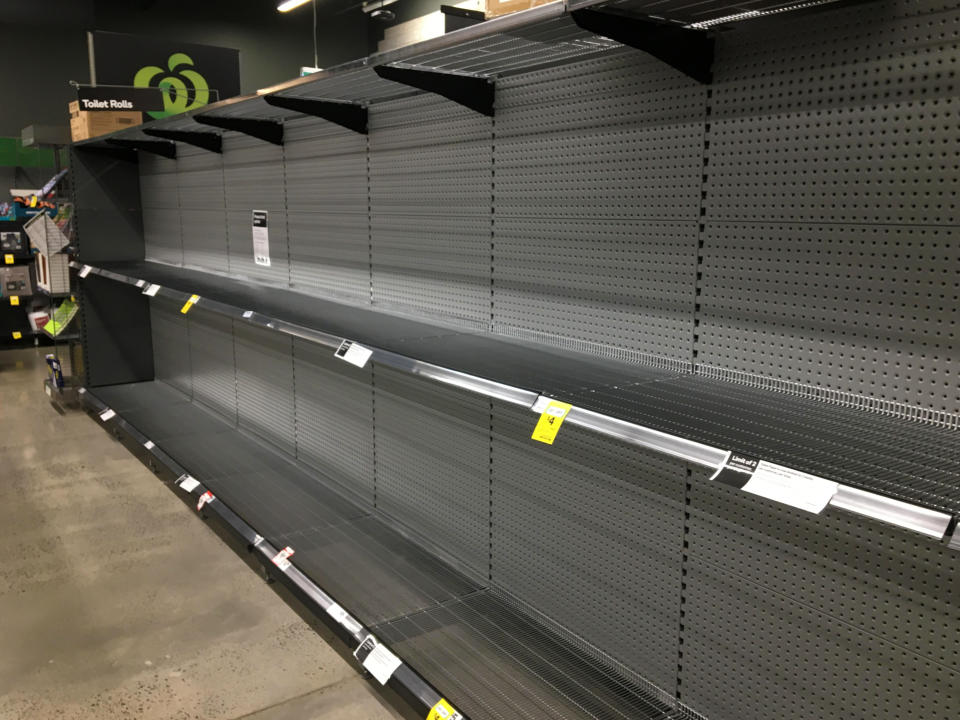 Empty toilet paper shelves are seen in a Woolworths Supermarket in Melbourne.