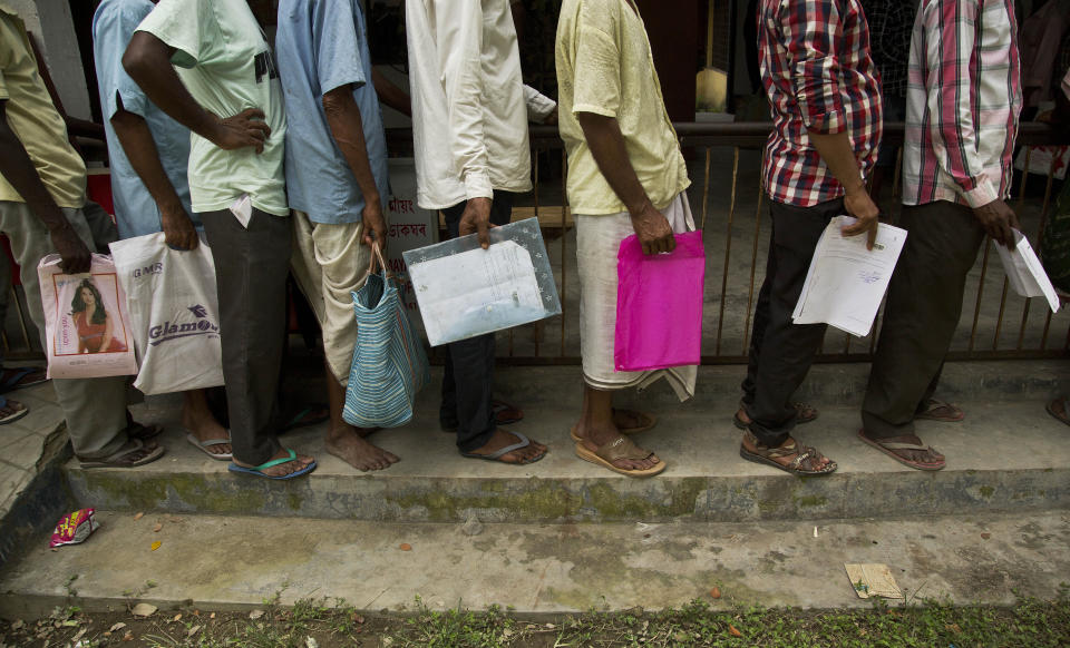 People whose names were left out in the National Register of Citizens (NRC) draft stand in a queue to collect forms to file appeals in Mayong, 45 kilometers (28 miles) east of Gauhati, India, Friday, Aug. 10, 2018. A draft list of citizens in Assam, released in July, put nearly 4 million people on edge to prove their Indian nationality. Nativist anger churns through Assam, just across the border from Bangladesh, with many believing the state is overrun with illegal migrants. (AP Photo/Anupam Nath)