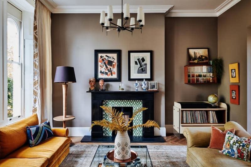 Brown living room with large windows and colorful accents