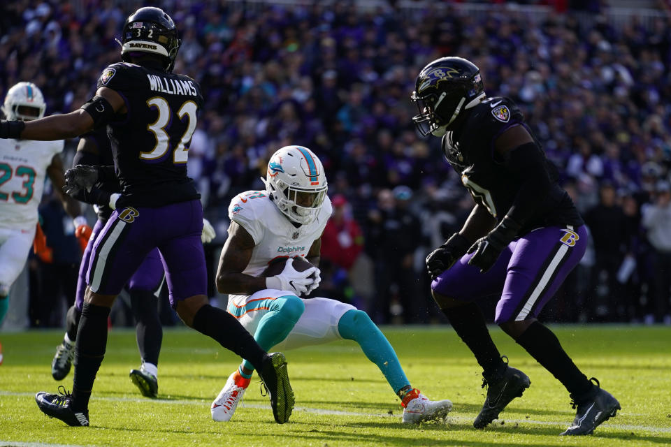 Miami Dolphins wide receiver Cedrick Wilson Jr., center, catches a touchdown pass against Baltimore Ravens safety Marcus Williams, left, and Roquan Smith, right, during the first half of an NFL football game in Baltimore, Sunday, Dec. 31, 2023. (AP Photo/Matt Rourke)