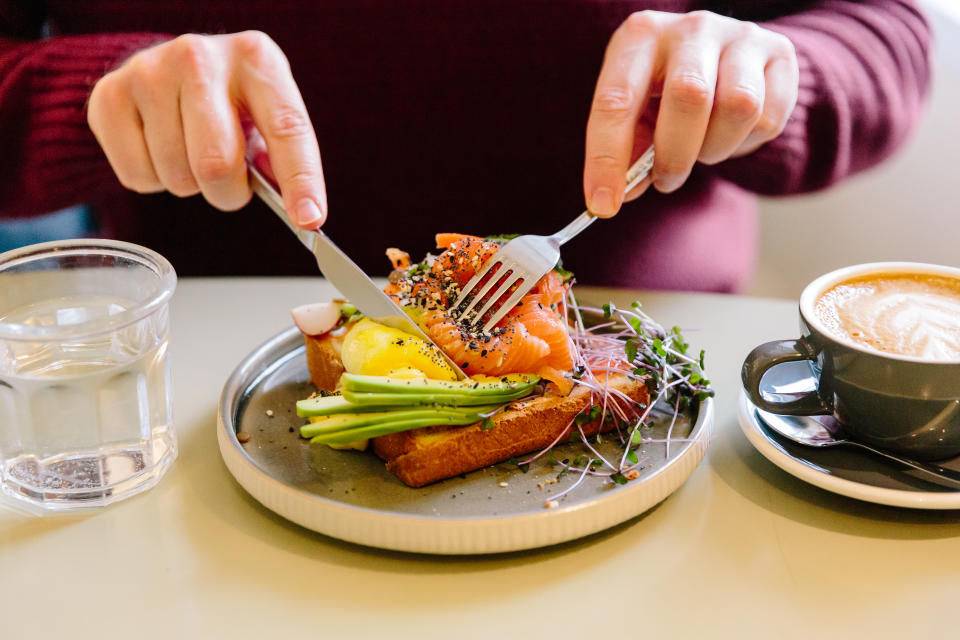 person eating avocado and salmon. (Getty Images)