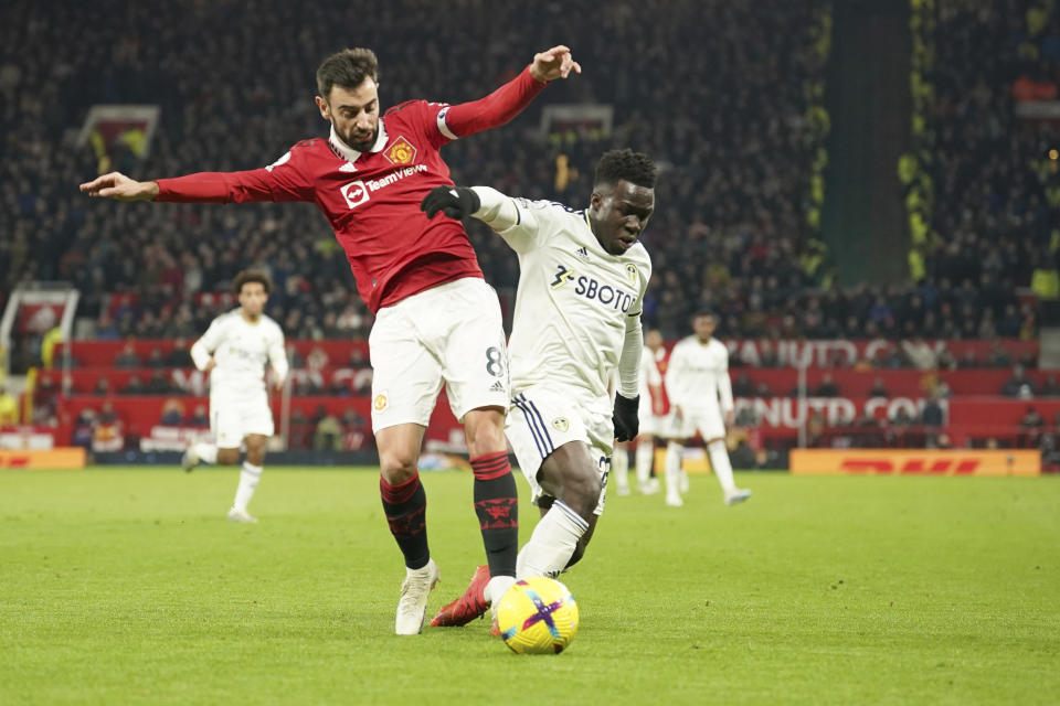 Manchester United's Bruno Fernandes, left vis for the ball with Leeds United's Wilfried Gnonto during the English Premier League soccer match between Manchester United and Leeds United at Old Trafford in Manchester, England, Wednesday, Feb. 8, 2023. (AP Photo/Dave Thompson)