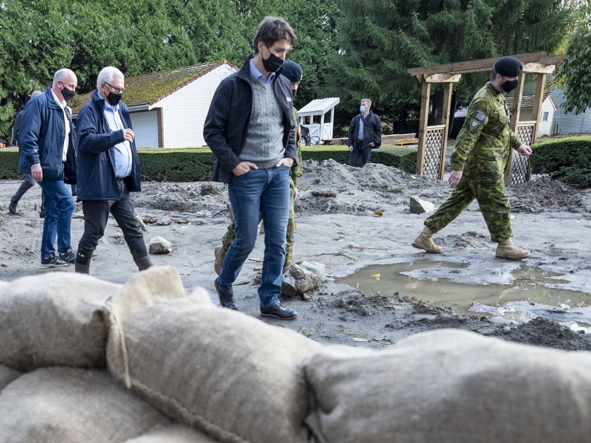 Prime Minister Justin Trudeau surveys the damage left behind from the flood waters in Abbotsford, B.C., on Friday. (Jonathan Hayward/The Canadian Press - image credit)