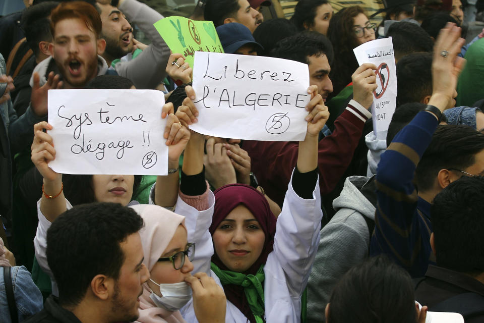 Hundreds of students gather with posters reading "system, get out" or "Free Algeria" in central Algiers to protest Algerian President Abdelaziz Bouteflika's decision to seek fifth term, Tuesday, March 6, 2019. Algerian students are gathering for new protests and are calling for a general strike if he doesn't meet their demands this week. (AP Photo/Fateh Guidoum)