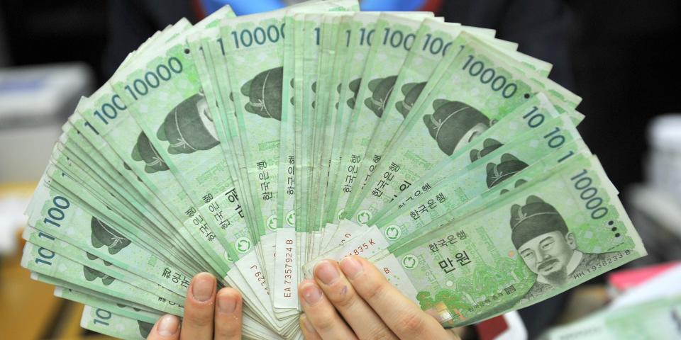 A bank employee holds South Korean won banknotes at the Korea Exchange Bank in Seoul.